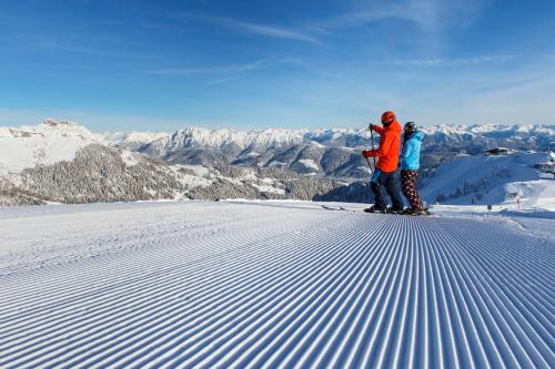 two people standing on top of a snow covered mountain at Ferienhaus Bella Vista in Presseggersee