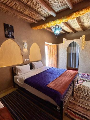 a bedroom with a large bed in a room at Riad dar merzouga in Merzouga