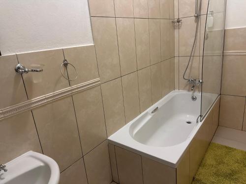 a bathroom with a bath tub and a toilet at 45 on Mendelssohn in Johannesburg