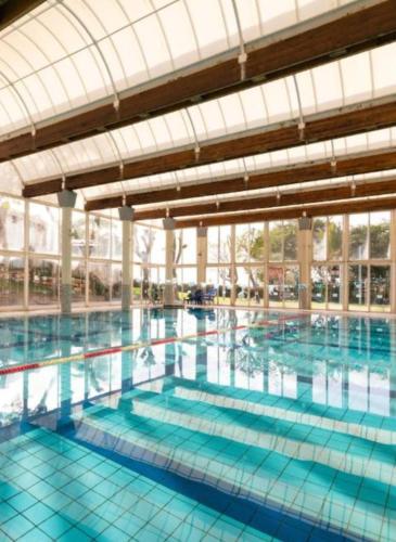 a large swimming pool with blue water at Rona Suite in Caesarea