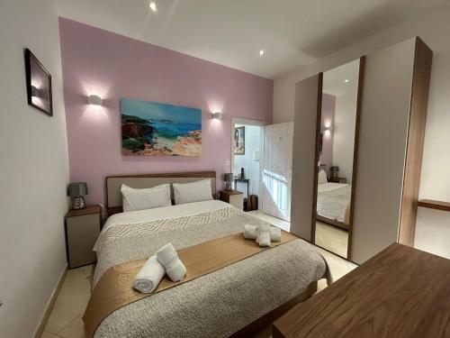 a bedroom with a large bed and a large mirror at Alina Boutique Living in Victoria