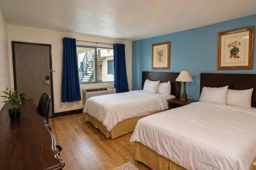 a hotel room with two beds and a window at Sacramento Inn & Suites Cal Expo I-80 in Sacramento