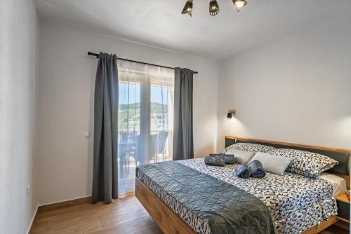 a bedroom with a bed and a large window at Milina Residence - Lumbarda in Lumbarda
