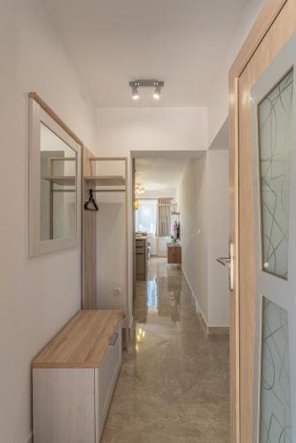 a hallway with a wooden bench and a mirror at Milina Residence - Lumbarda in Lumbarda