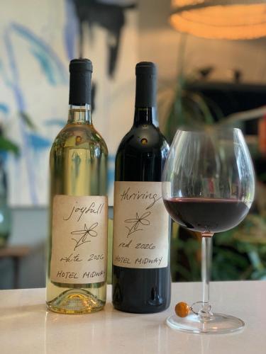 zwei Flaschen Wein und ein Glas auf einem Tisch in der Unterkunft Hotel Midway in Midway
