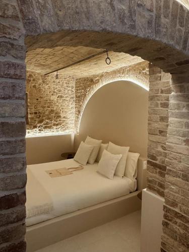 a bedroom with a bed in a brick wall at Gaeta Rooms in Lanciano