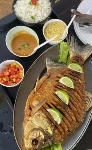 a plate of food with a fish and rice at The Temple, Laguna de la Cocha in El Encano
