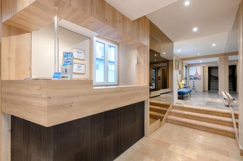 a living room with wood paneling and a staircase at Marmotel Etoile in Paris