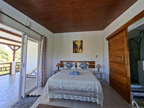 a bedroom with a bed and a large sliding glass door at Poisson d'Or Guest House in Port Mathurin