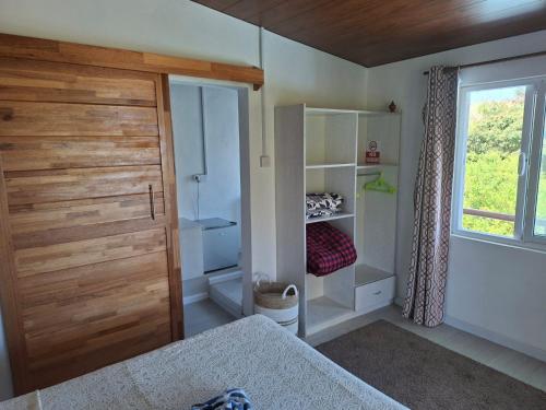 a bedroom with a closet and a bed with a window at Poisson d'Or Guest House in Port Mathurin