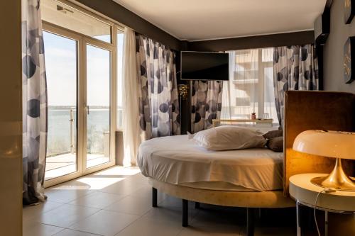 a bedroom with a bed and a large window at Vila Victor Mizuumi in Mamaia
