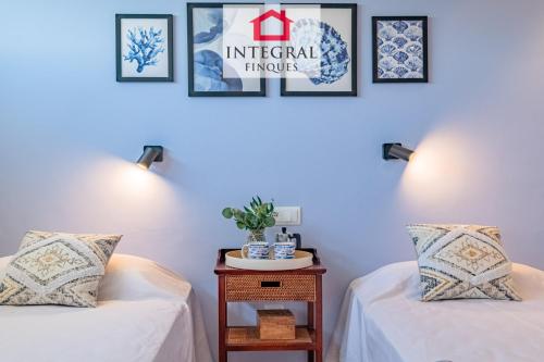 a room with two beds and a table with two pillows at Infinite View Palamós in Palamós