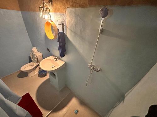 a small bathroom with a toilet and a shower at Riad dar merzouga in Merzouga