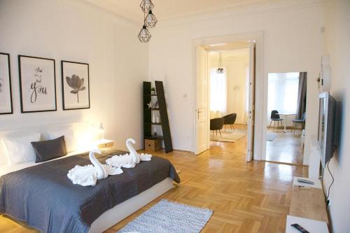 a bedroom with a bed with white swans on it at Five Season's Apartment in Budapest
