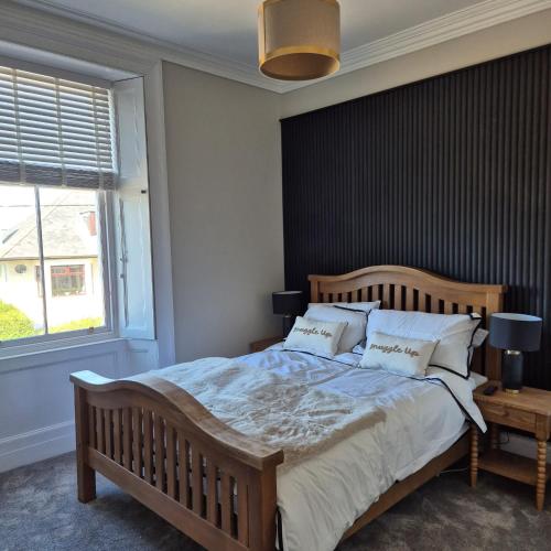a bedroom with a large bed and a window at Lochmaben in Lochmaben