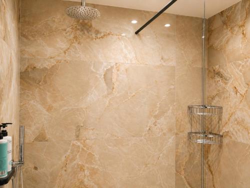 a bathroom with a shower with a stone wall at Morfeas City Hotel in Rhodes Town