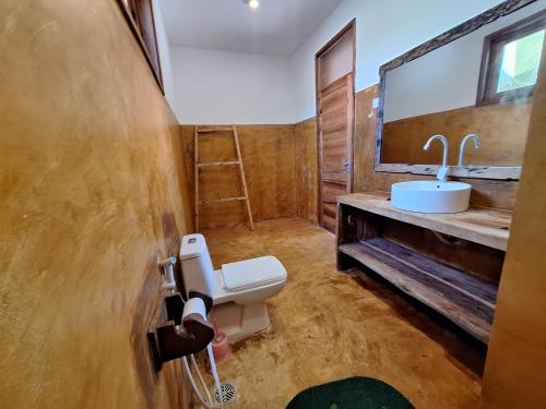 a bathroom with a toilet and a sink at Bwereusunsetbungalow in Kidoti
