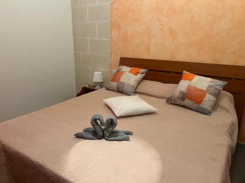 a stuffed animal is sitting on a bed at Galliu'S home in Selargius