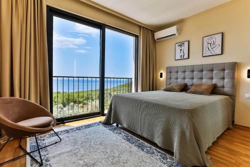 a bedroom with a bed and a large window at Poljana Olive Homes Pool Residences in Rijeka Reževići