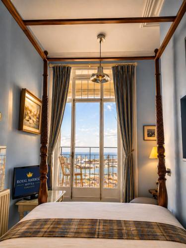a bedroom with a bed and a large window at The Royal Harbour Hotel in Ramsgate