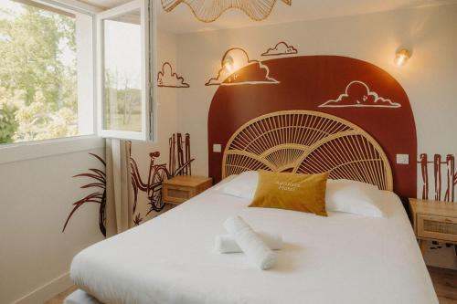 a bedroom with aumedumed bed with a large headboard at Adishatz Motel in Biscarrosse