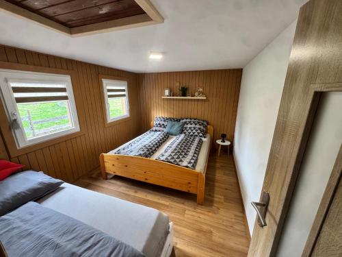 a small bedroom with a bed and a window at Chata Hugo in Česká Lípa