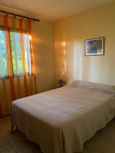 a bedroom with a white bed and a window at vigne maio in Ventiseri