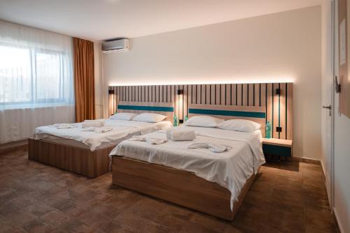 two beds in a hotel room with two bedsvisor at du Mio in Eforie Nord
