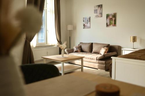 a living room with a couch and a table at Olive Residence Lübeck in Lübeck