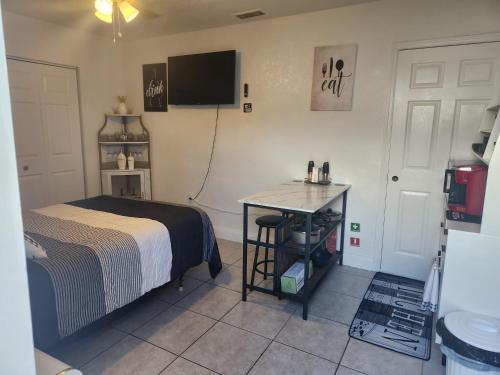 a bedroom with a bed and a table and a tv at Comfy hideaway in Hollywood