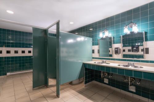 a bathroom with two sinks and two mirrors at Prestige Prince George Lodge in Prince George