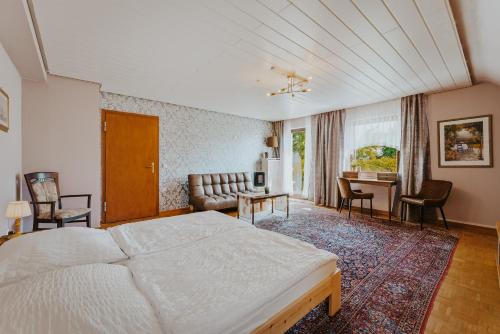 a bedroom with a bed and a living room at Pension Haus Elmar in Rösrath