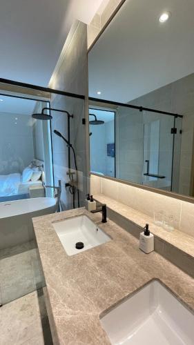 a bathroom with a sink and a large mirror at Villa Tierra Pattaya in North Pattaya