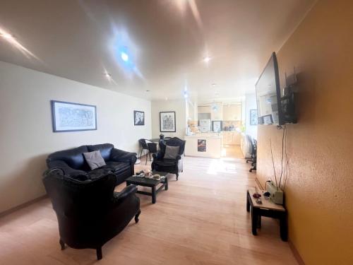 a living room with black couches and a tv at Subvolcanic Point in Arequipa