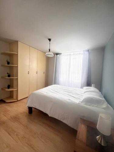 a bedroom with a large white bed and a window at Subvolcanic Point in Arequipa