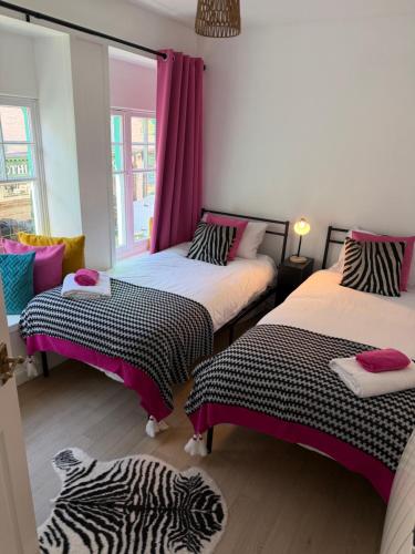 a room with two beds and a zebra blanket at Well St Apartment in Moffat