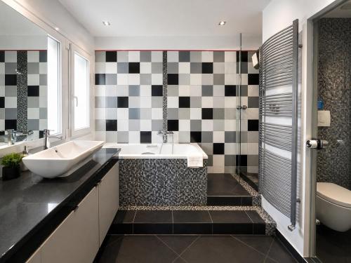 a bathroom with a sink and a tub and a toilet at Premium Seafront Suite in Thessaloniki