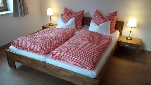 a bedroom with a bed with red and white pillows at FEWO "Unterm Wald" in Stumm