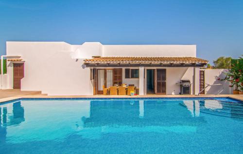 a villa with a swimming pool in front of a house at Murta 26 in Sa Coma
