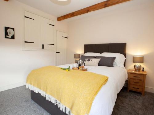 a bedroom with a large bed with a yellow blanket on it at 2 Bed in Richmond oc-74284 in Reeth