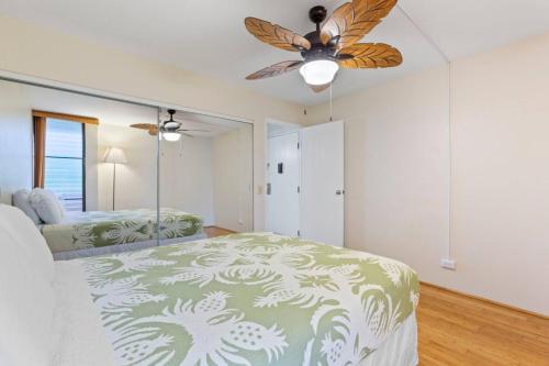 a bedroom with a bed and a ceiling fan at Maalaea Banyans Oceanfront in Wailuku