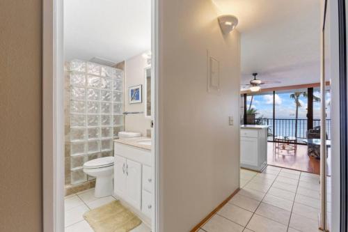 a bathroom with a toilet and a view of the ocean at Maalaea Banyans Oceanfront in Wailuku