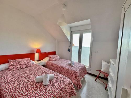 a bedroom with two beds and a window at Duplex primera linea La Arena 4607 in Arnuero
