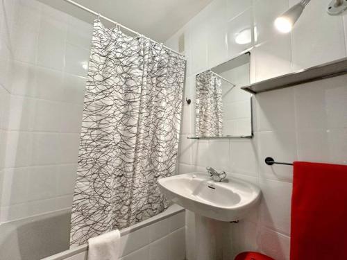 a bathroom with a sink and a shower curtain at Duplex primera linea La Arena 4607 in Arnuero