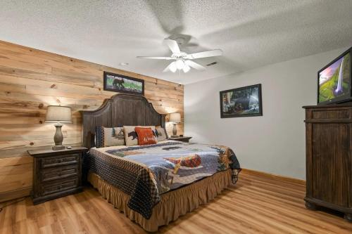 a bedroom with a bed and a ceiling fan at Hillside Happiness GameRoom Grill Firepit MORE in Sevierville