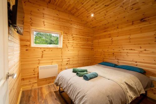 a bedroom with a bed in a wooden cabin at The Cabin in Mountfield