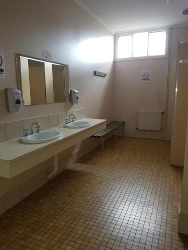 Baño con 2 lavabos y espejo en Mansfield Travellers Lodge, en Mansfield