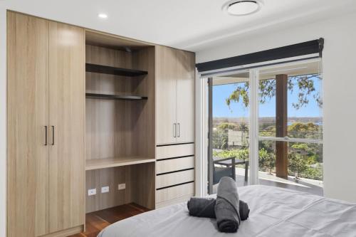 a bedroom with a bed and a large window at Lakeview Luxury in Budgewoi