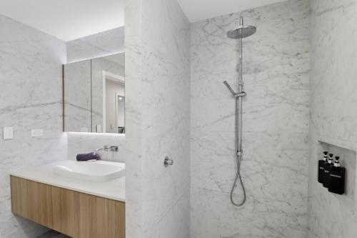 a white bathroom with a sink and a shower at Lakeview Luxury in Budgewoi