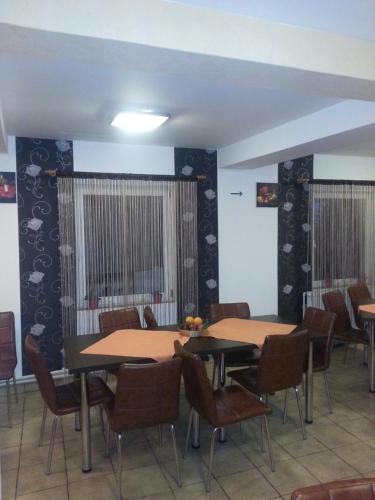 uma sala de jantar com duas mesas e cadeiras em Vila MDM em Straja
